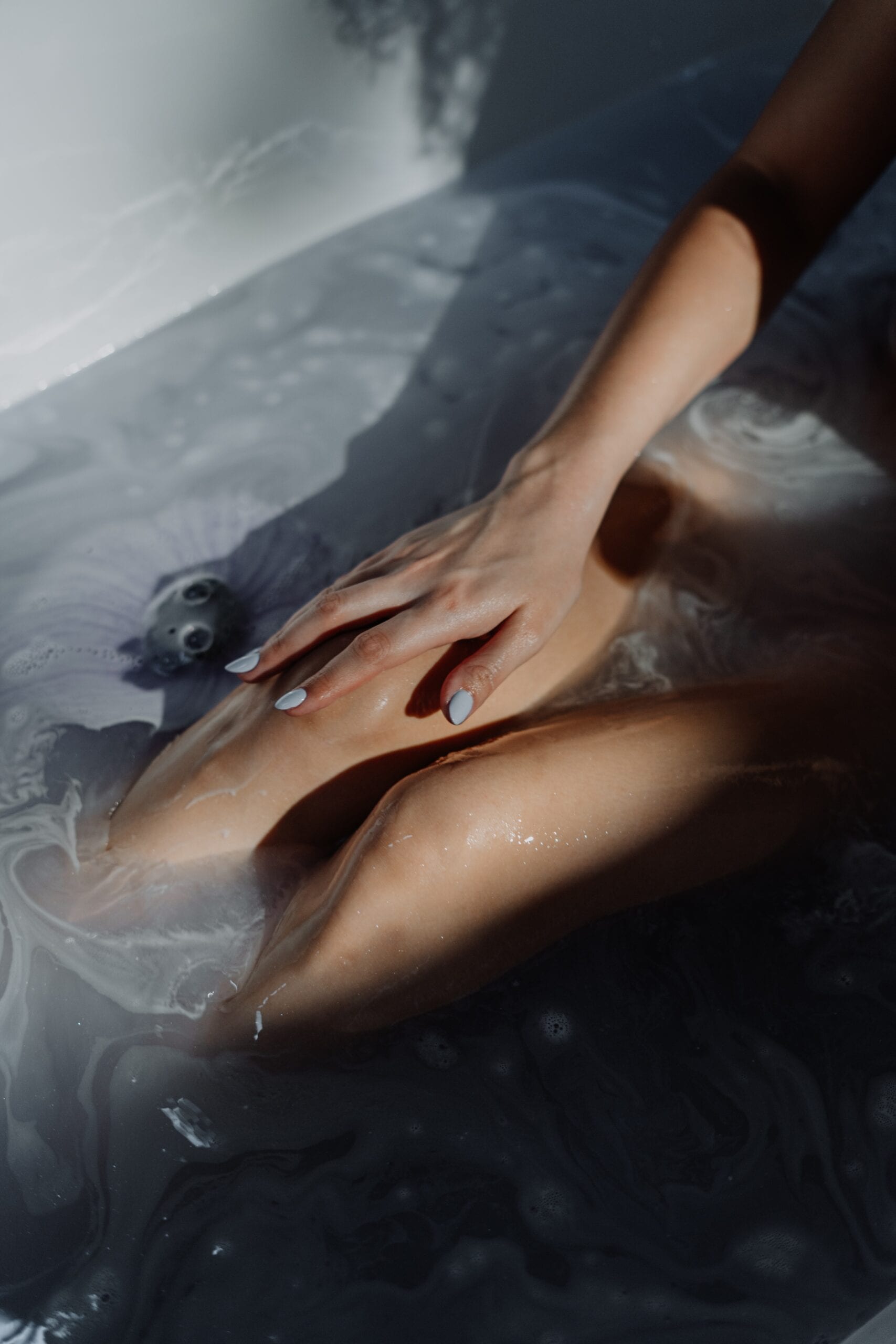 Kvinde sidder i et badekar af aromatiske dufte